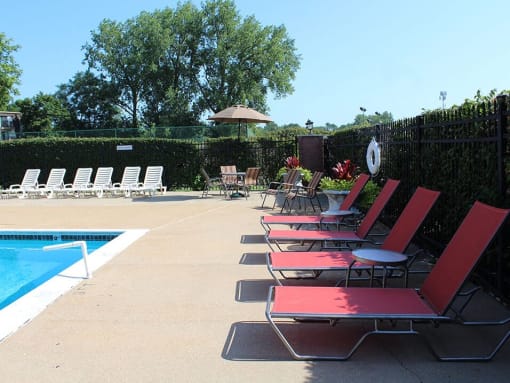 a group of red chairs sitting next to a swimming pool