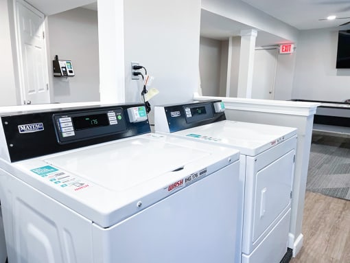 a laundry room with two washers and two dryers
