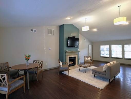 a living room with a fireplace and a table and chairs