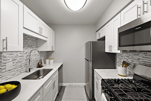 A kitchen with a black stove top oven and a black refrigerator.
