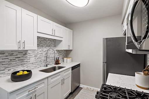A kitchen with a black stove top oven and a white counter top.