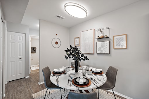 A dining room with a round table set for a meal.