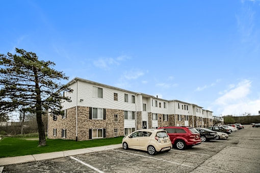 A parking lot with cars and a building in the background.