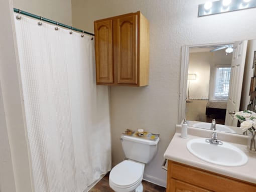 A white toilet sits next to a white sink in a small bathroom.