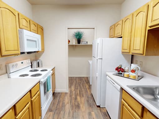 A kitchen with wooden cabinets and white appliances.