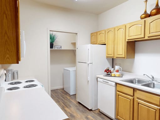 A kitchen with a white stove top and wooden cabinets.