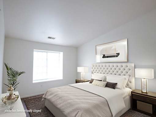 A bedroom with a large bed and a painting above it.