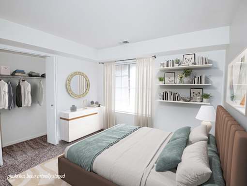 A bedroom with a large bed and a clothing rack.