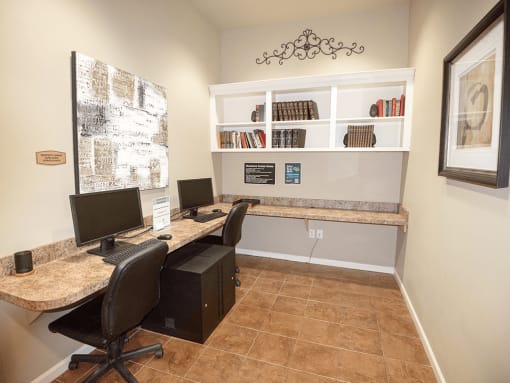 a home office with two computer desks and two chairs