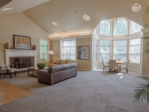 a living room with a couch and a fireplace and a table and chairs