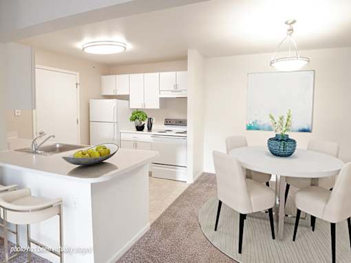 A kitchen with a table and chairs.