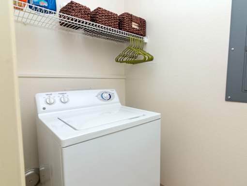 A white washing machine sits in a laundry room.