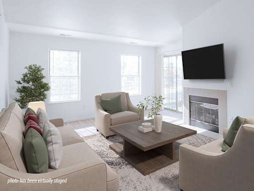 A living room with a couch, chairs, a coffee table, and a fireplace.