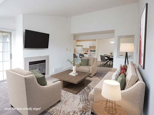A living room with a fireplace, two couches, and a television.