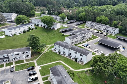 A bird's eye view of a residential area with multiple houses and cars.