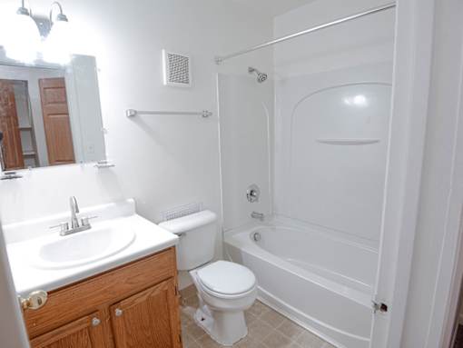 A white bathroom with a toilet, sink, and bathtub.