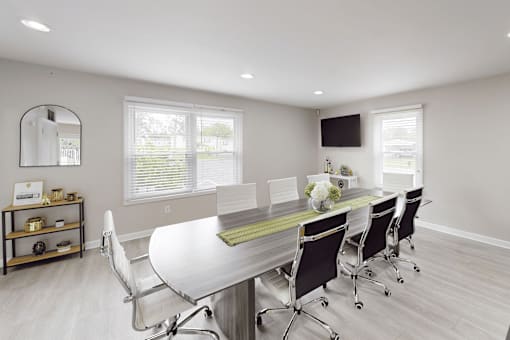 A white table with chairs and a mirror on the wall.