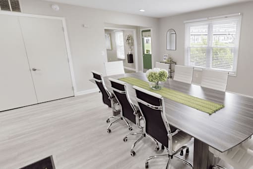 A conference room with a long table and chairs.