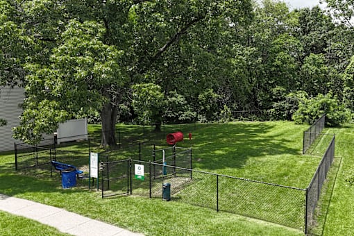 A green fenced area with a red ball and a sign.