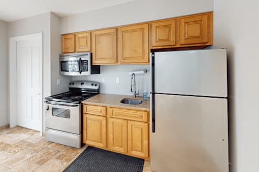 A kitchen with a refrigerator, stove, and oven.