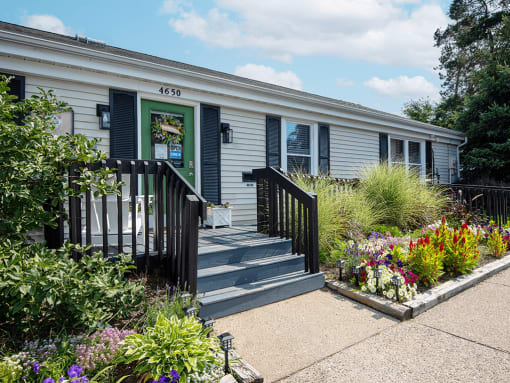 the exterior of rolling pines office with a garden in front of it