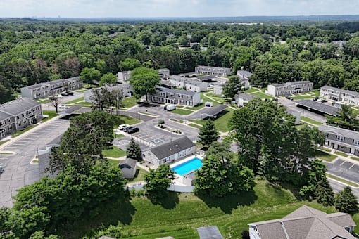 A bird's eye view of an apartment complex with a swimming pool.