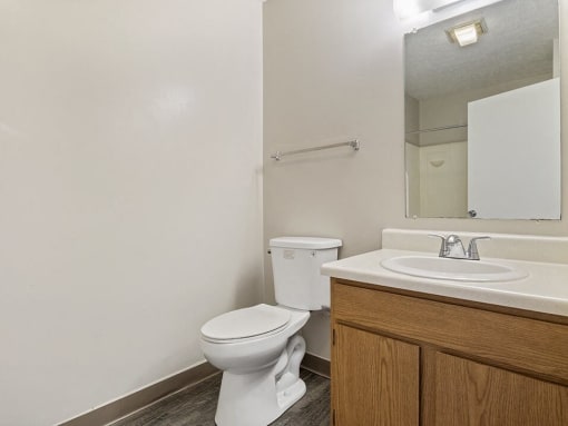 apartment bathroom with a toilet sink and mirror