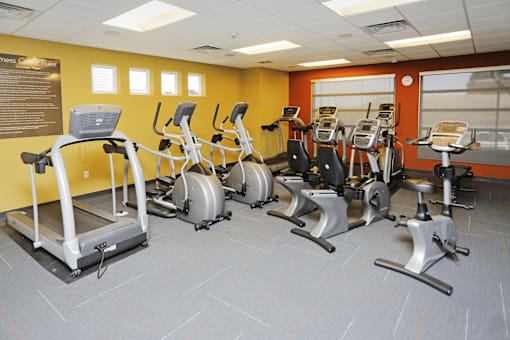 A gym with treadmills, exercise bikes, and elliptical machines.