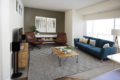 A living room with a blue couch and a fireplace.