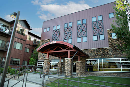 A building with a red roof and a stone pillar in front.
