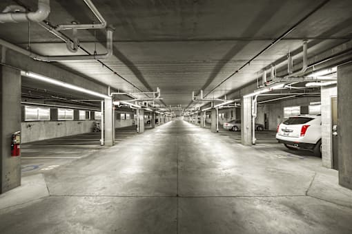A long, narrow parking garage with concrete floors and walls.