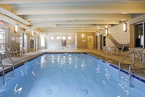 A large indoor swimming pool with a blue tiled floor and walls.