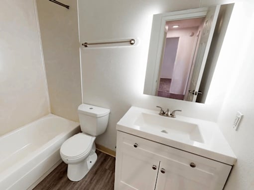 A white bathroom with a toilet, sink, and bathtub.