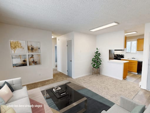 A living room with a couch, coffee table, and pictures on the wall.