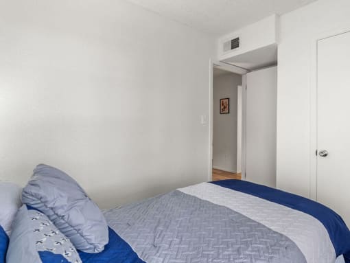 a bedroom with a bed and a door to a hallway