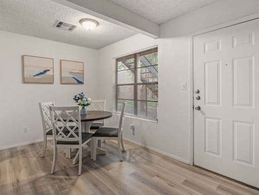 a dining room with a table and chairs and a window