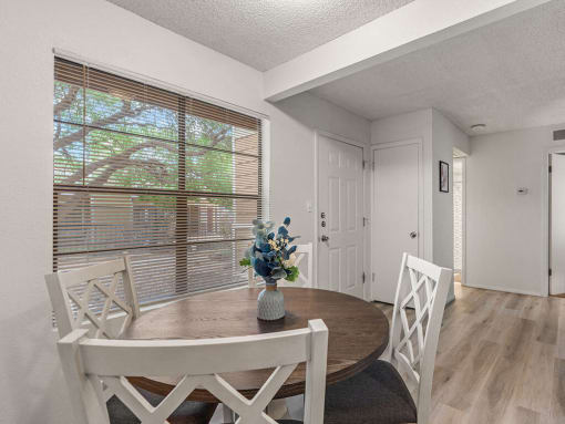 a dining room with a table and chairs and a window