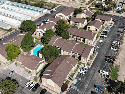 A bird's eye view of a residential area with houses and parked cars.