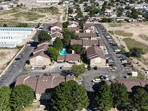 A bird's eye view of a residential area with houses and parked cars.