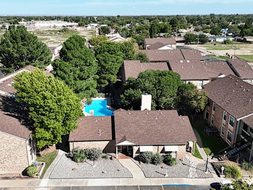 A bird's eye view of a residential area with houses and a swimming pool.