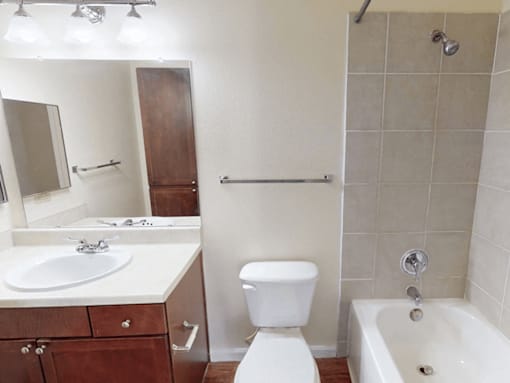 A white toilet sits next to a white sink in a bathroom.