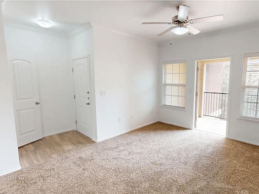 A room with a ceiling fan and carpeted floor.