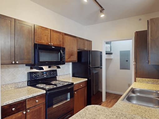 A kitchen with black appliances and wooden cabinets.