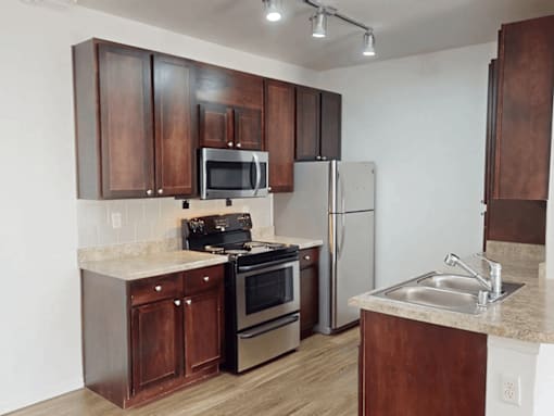 A kitchen with brown cabinets and stainless steel appliances.