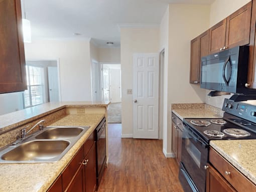 A kitchen with wooden cabinets and a black stove top oven.
