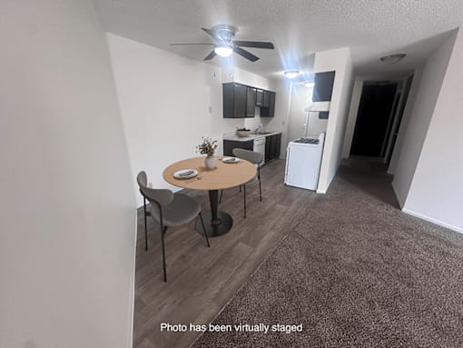 A photo of a living room with a dining table and chairs.