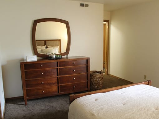 a bedroom with a dresser and a bed