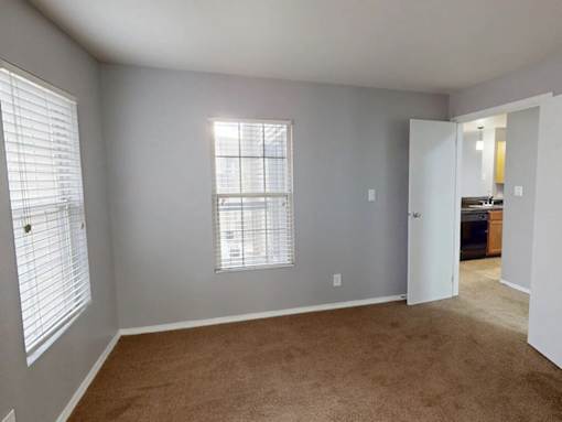 A room with a window and a door leading to another room.