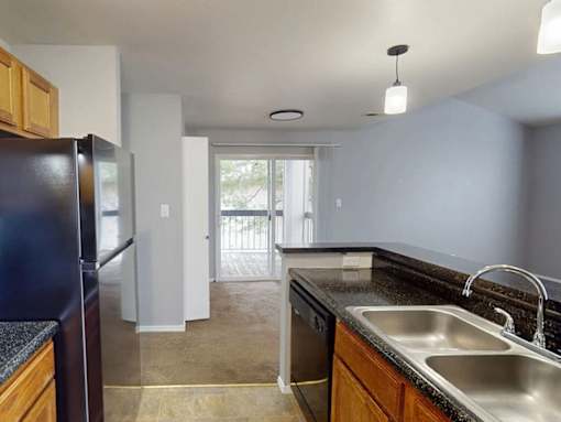 A kitchen with a black fridge and a sink.