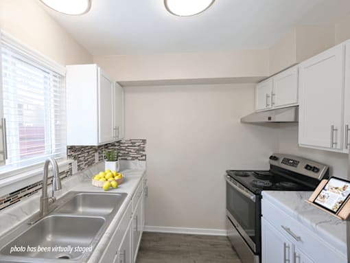 A kitchen with a stove, sink, and countertop.